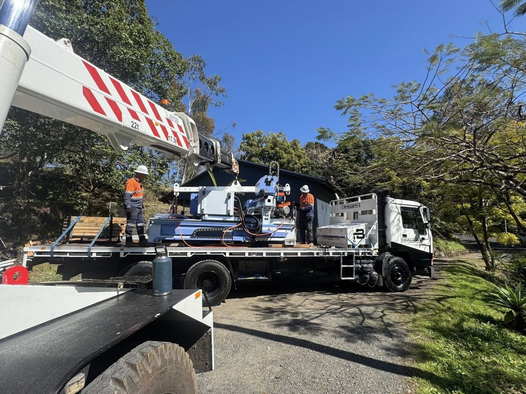 Crane lifting item onto truck - bauer cranes